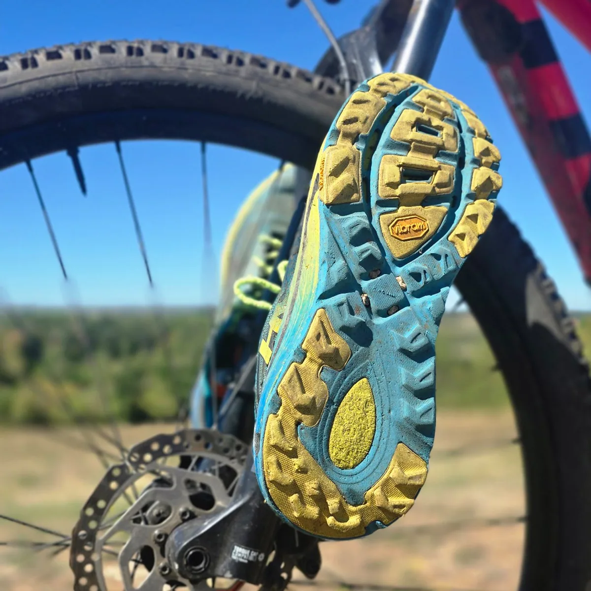 Chaussures transportées sur la fourche d’un VTT avec le Kit porte-chaussures FIXATRAX